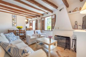 a living room with white furniture and a fireplace at Villa Cami de la Mar in Port de Soller