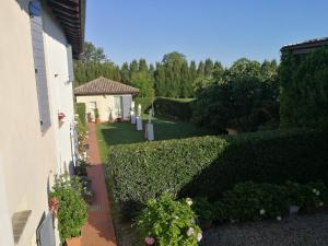 Blick auf einen Garten mit Büschen und ein Haus in der Unterkunft Agriturismo Fattoria Corte Roeli in Malalbergo