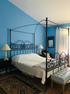 um quarto com uma cama de dossel e paredes azuis em Dona Maria 66 na Praia da Luz