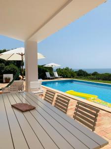 um pátio com uma mesa e cadeiras ao lado de uma piscina em Dona Maria 66 na Praia da Luz