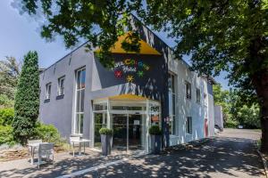 a building with a sign on the front of it at Hôtel Full Colors in Craponne