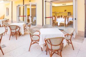 a group of tables and chairs in a restaurant at Hotel Centrale in Garda