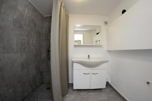 a white bathroom with a sink and a shower at Hotel Victoria in Mamaia +47 photos