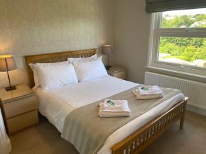 a bedroom with a bed with two towels on it at Braemar in Falmouth