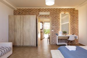 Un dormitorio con una cama y una pared de ladrillo. en Kahlua Bay Apartments, en Hersonissos 32 fotos más