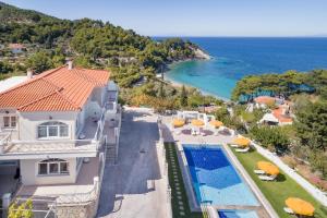 an aerial view of a house with a swimming pool and the ocean at PENNY LUXURY APARTMENTS in Kokkari
