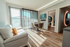 uma sala de estar com um sofá e uma mesa em PRADA' Home Eco Suites em Bardolino