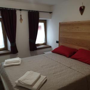 a bedroom with a bed with two towels on it at Casa Tiziano e Nila in Santo Stefano di Cadore