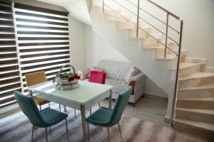 a living room with a table and chairs and a staircase at The Era Otel in Gölhisar