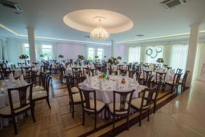 una sala banchetti con tavoli e sedie bianchi di Hotel Grodzisko a Grodzisk Mazowiecki