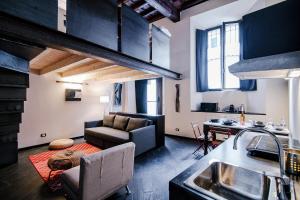 a kitchen and living room with a couch and a table at Palazzo Del Pero - The House Of Travelers in Como