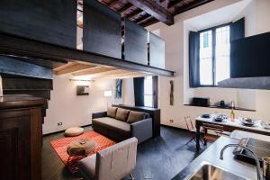 a kitchen and living room with a couch and a table at Palazzo Del Pero - The House Of Travelers in Como