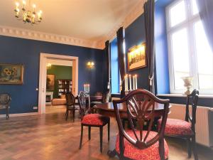 une salle à manger avec des murs bleus, une table et des chaises dans l'établissement Schlosshotel Gross Koethel, à Hohen Demzin