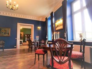 a dining room with blue walls and a table and chairs at Schlosshotel Gross Koethel in Hohen Demzin