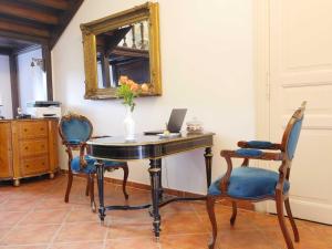 a room with a desk with a laptop and chairs at Schlosshotel Gross Koethel in Hohen Demzin