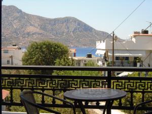 una mesa y sillas en un balcón con vistas al océano en Studios Eftichia, en Fourni Ikarias