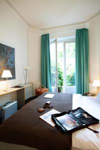 Habitación de hotel con cama con cortinas verdes en Aussen Alster Hotel, en Hamburgo