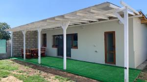 a patio with a pergola on a white house at Shabla Lux Guest Houses in Shabla