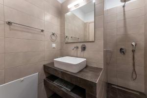 La salle de bains est pourvue d'un lavabo blanc et d'un miroir. dans l'établissement Ilianas Home, à Kalamata