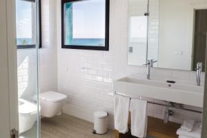 a white bathroom with a sink and a toilet at Hotel Almirante in Alicante