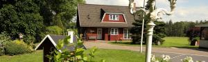 a red house with a sign in front of it at Ferienwohnung LOLA in Hohenlockstedt