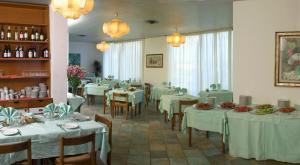 ソヴェラート・マリーナにあるHotel Nettunoの白いテーブルクロスのテーブルと椅子が備わるレストラン