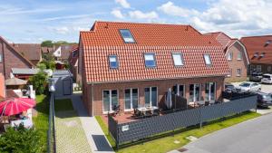 une grande maison en briques avec un toit rouge dans l'établissement Ferienhaus Deichstraße 8, à Carolinensiel