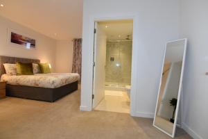 a bedroom with a bed and a walk in shower at Kew Bridge Apartments in London