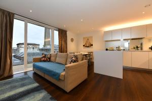 a living room with a couch and a kitchen at Kew Bridge Apartments in London