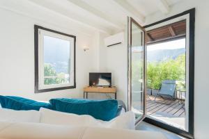 een woonkamer met een bank en een glazen schuifdeur bij P Terrace - Lake View by Rent All Como in Laglio