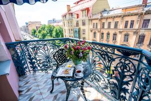 una mesa con un jarrón de flores en el balcón en Akyan St.Petersburg, en San Petersburgo