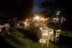 eine Gruppe von Tischen und Stühlen im Gras bei Nacht in der Unterkunft Cascina Borgofrancone in Gera Lario