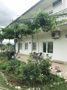 um edifício com uma mesa e cadeiras em frente em Apartments Nena em Lozovac