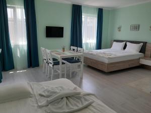 a bedroom with two beds and a table with chairs at La MER 2 in Tsarevo