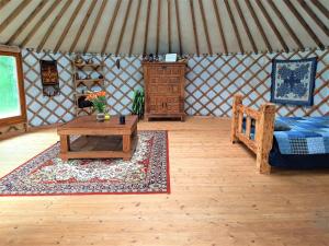um quarto com uma cama e uma mesa numa tenda em Jurtos nuoma em Kartena