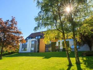 a building on a hill with trees in the foreground at SGV Jugendhof in Arnsberg