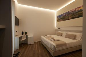 a white bedroom with a bed and a desk at Orizzonte MHotel in Andria