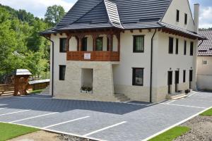 a house with a gambrel roof on a parking lot at Pensiunea ARMONIA in Văleni
