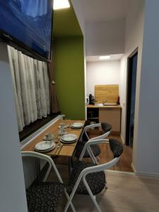 comedor con mesa y 4 sillas en Ambient Deluxe Apartman en Gyula