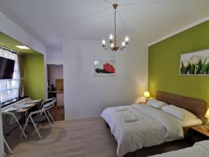a bedroom with a bed with a green wall at Ambient Deluxe Apartman in Gyula