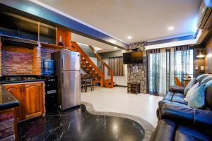 a kitchen and a living room with a refrigerator at CLOCKWORKORANGE Luxury Suites in Mactan
