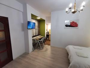 a bedroom with a bed and a dining room at Ambient Deluxe Apartman in Gyula
