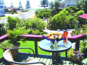 a bowl of fruit on a table on a patio at Moanarua Beach Cottage in Ohope Beach