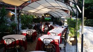 a group of tables with red and white table cloth at Hotel Villa Robinia in Genzano di Roma