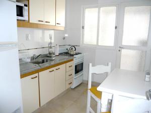 a kitchen with white cabinets and a sink and a table at Departamento de dos dormitorios para 6 personas en el centro in Buenos Aires