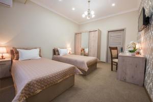 a bedroom with two beds and a desk and a chair at Huzur Hotel Tashkent in Tashkent +36 photos