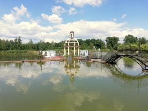 a building in the middle of a lake with a bridge at Hotel Venecia Palace in Michałowice
