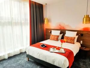 a hotel room with a bed with a tray with flowers on it at Abbaye des Capucins Spa & Resort in Montauban