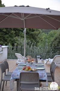 a table with an umbrella on a patio at B&B Cyparus in Venarotta