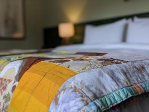 a bed with a colorful quilt on top of it at Thistle Cottage, CrannachCottages in Garve